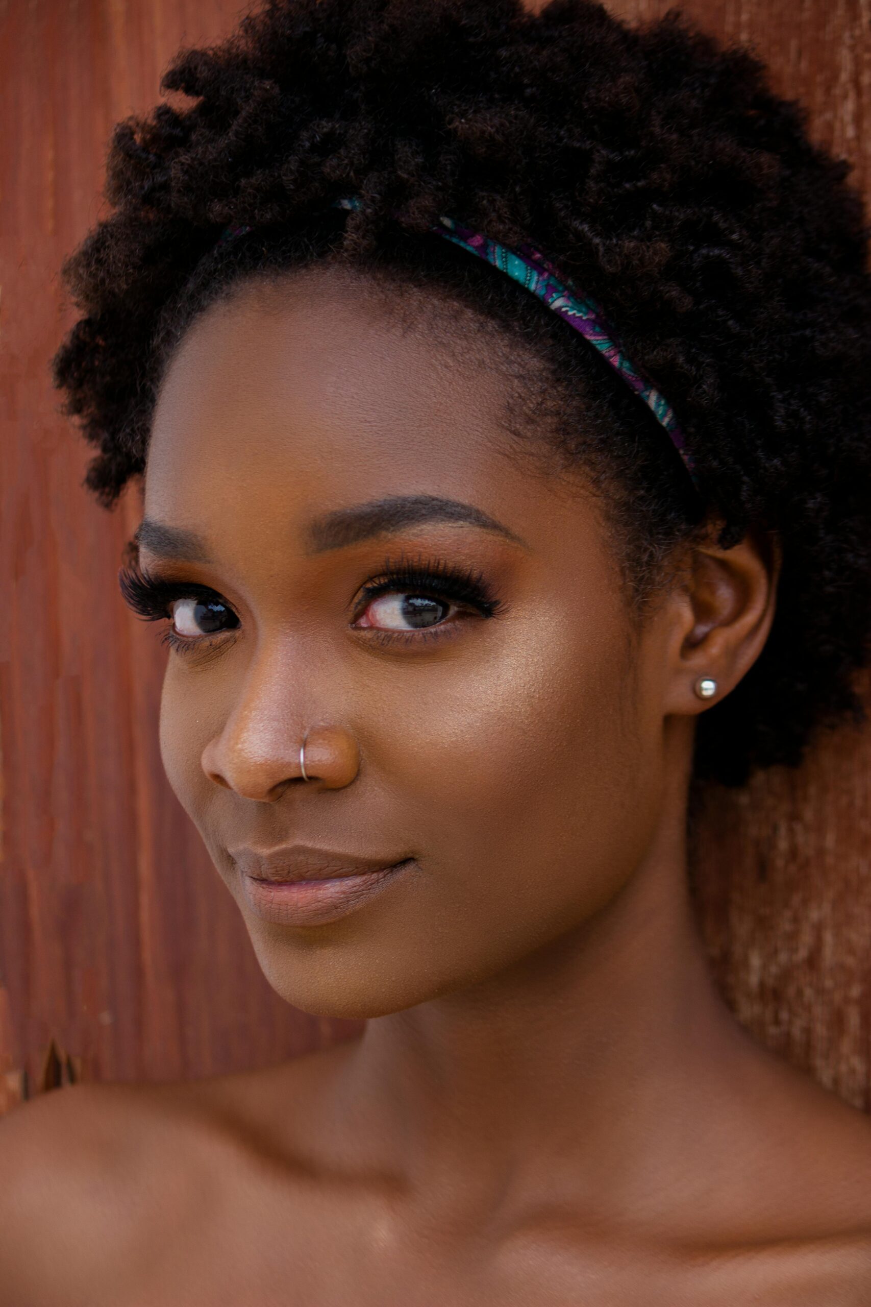 Close-up portrait of a beautiful woman with afro hairstyle, showcasing natural beauty in an outdoor setting.